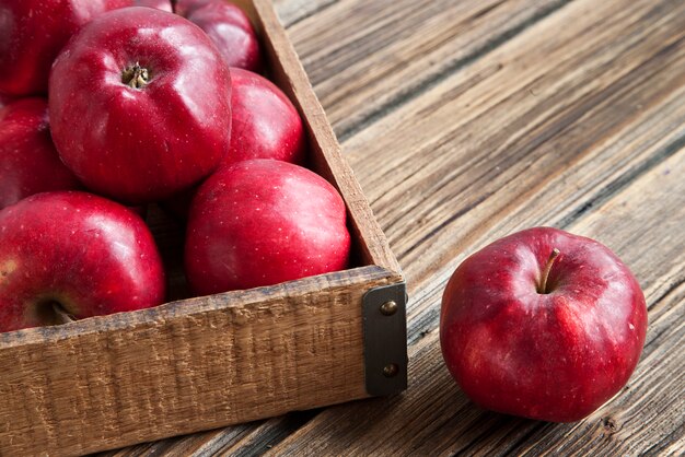 Pommes rouges fraîches dans une boîte en bois