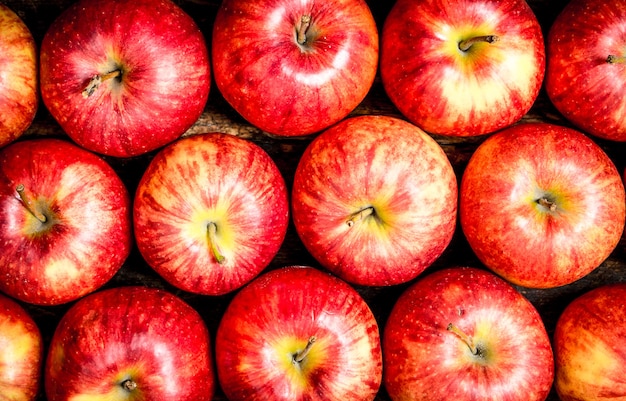 Pommes rouges fraîches sur fond de bois