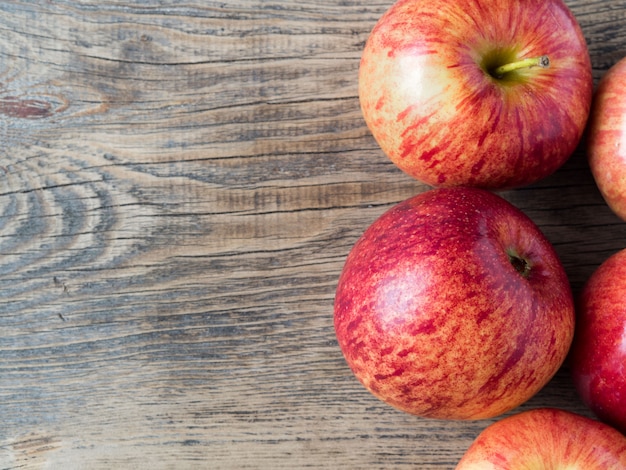 Pommes rouges juteuses mûres sur une table en bois, vue de dessus