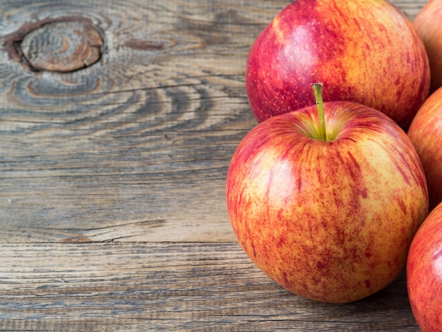 Pommes rouges juteuses mûres sur une table en bois