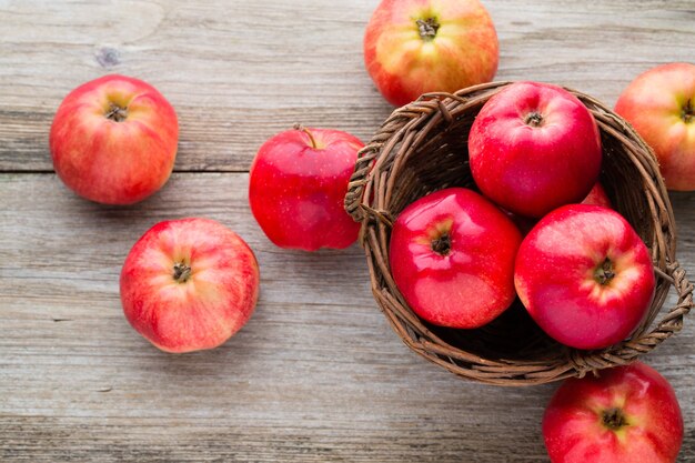 Pommes rouges mûres sur fond en bois.