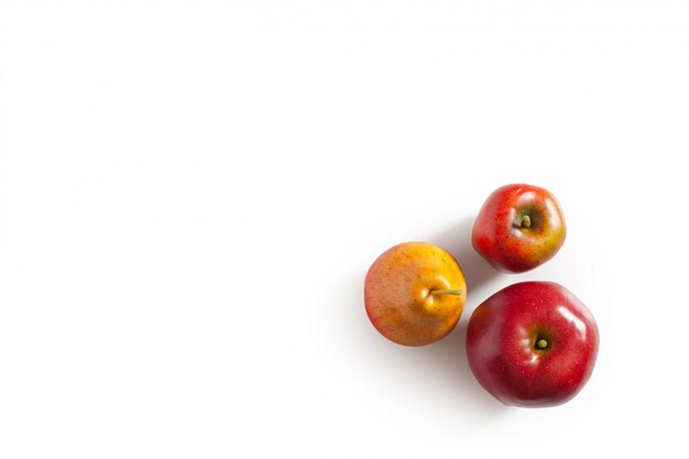 Pommes rouges et poire sur blanc