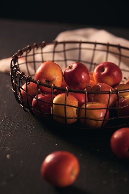 Pommes rouges savoureuses lumineuses dans un panier, plan rapproché