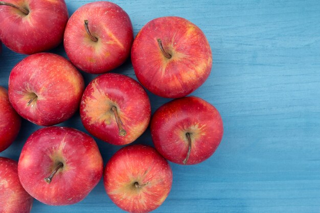 Pommes rouges sur une table bleue