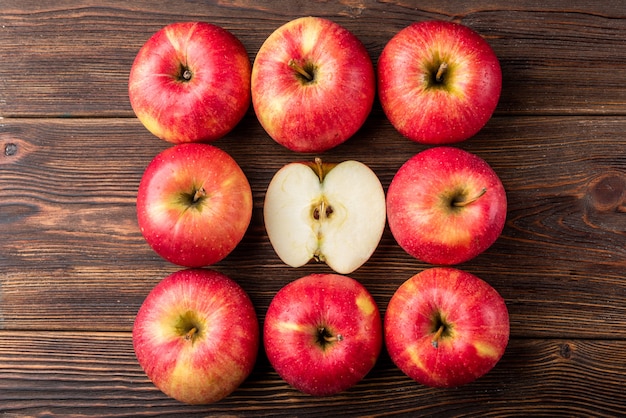 Pommes rouges sur table en bois sombre.