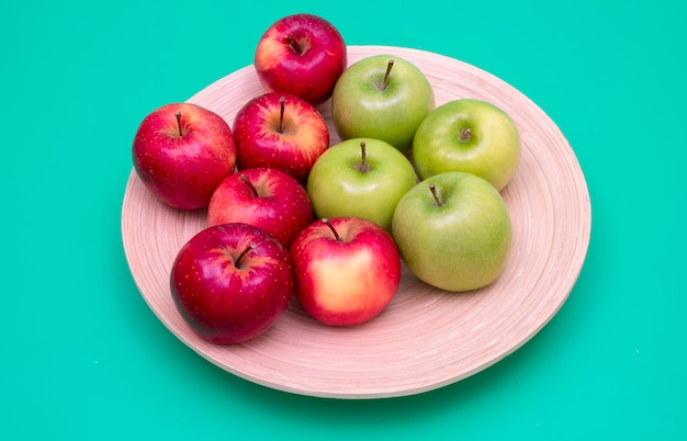 Pommes rouges et vertes sur une plaque de bambou