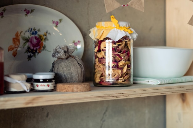 Pommes séchées dans un bocal et de la confiture sur une étagère Étagère alimentaire rustique