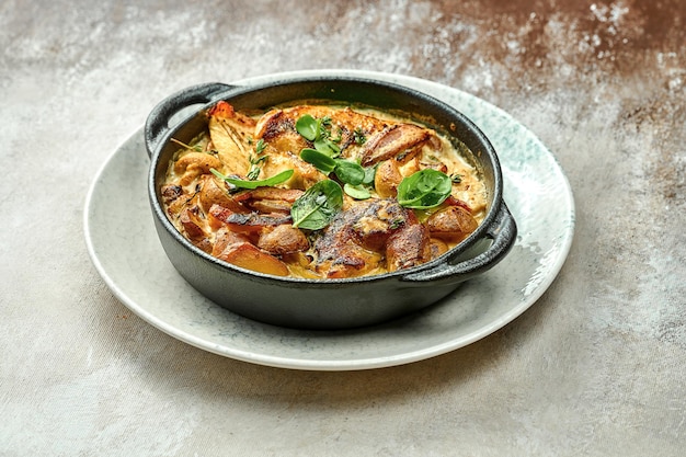 Pommes de terre au four dans une sauce crémeuse avec du poulet et du fromage. Gros plan, mise au point sélective