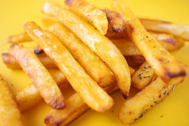 Pommes de terre au four avec des herbes aromatiques sur un fond jaune.