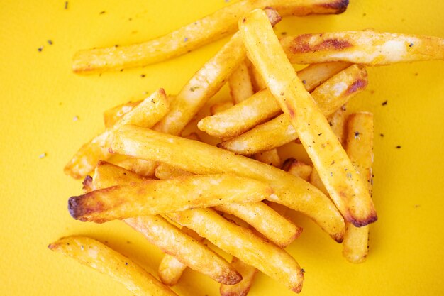 Pommes de terre au four avec des herbes aromatiques sur un fond jaune.