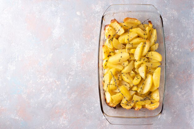 Pommes de terre au four avec de l'huile d'olive, de l'ail et du thym sous forme de verre. Mise à plat, vue de dessus.