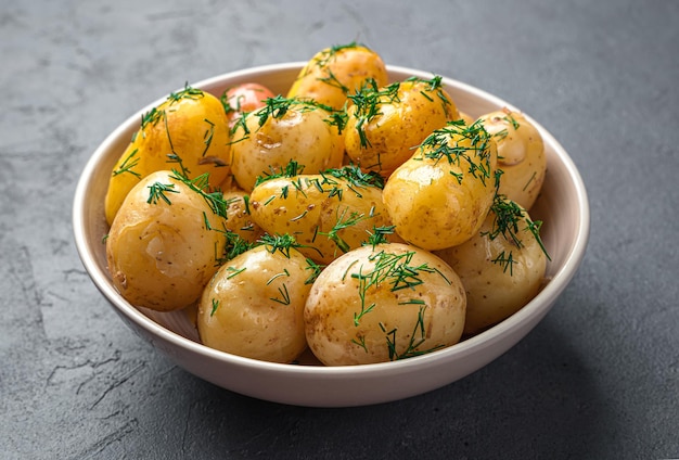 Pommes de terre bouillies à l'aneth et au beurre gros plan sur fond sombre