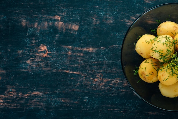 Pommes de terre bouillies à l'aneth dans un bol Sur un fond en bois Vue de dessus Espace de copie