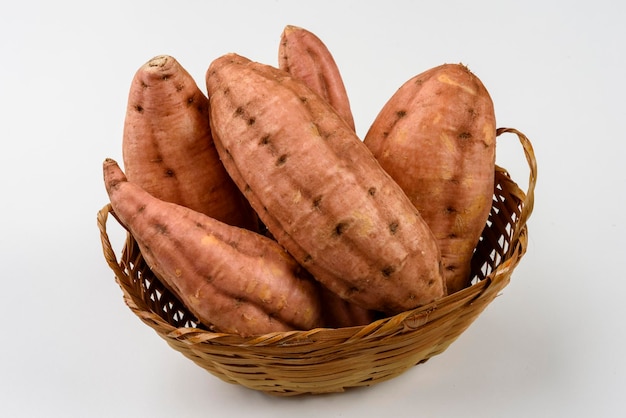 Pommes de terre carottes douces dans un panier isolé sur fond blanc