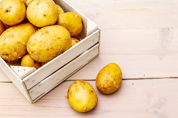 Pommes de terre crues fraîches dans une boîte en bois