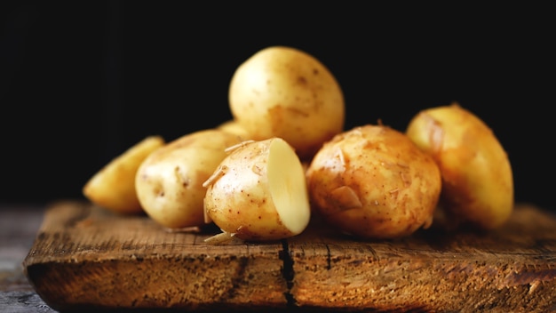 Pommes de terre crues sur une surface en bois