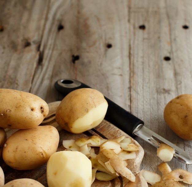 Pommes de terre crues avec une vue de dessus d'éplucheur de légumes