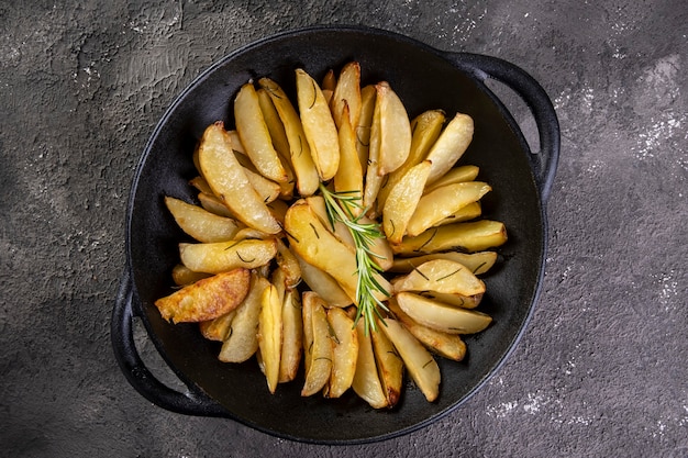 Pommes de terre cuites dans une cocotte en fer avec du romarin et de l'huile d'olive.