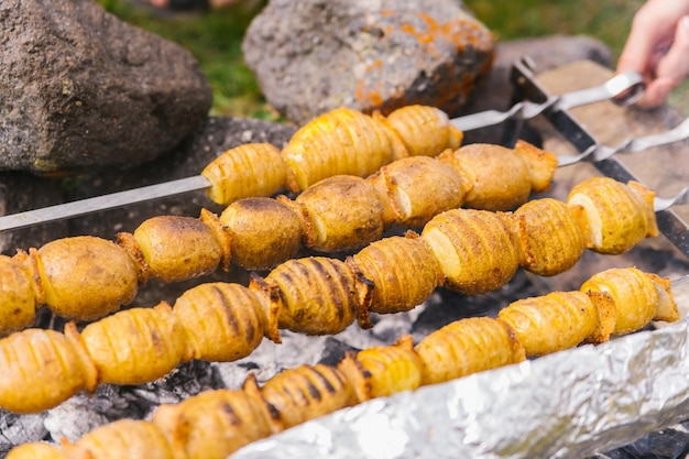 Pommes de terre entières de manière rustique sur des brochettes Une délicieuse collation pour une fête d'été avec un barbecue en plein air ou un pique-niqueCuisine maison Végétarisme