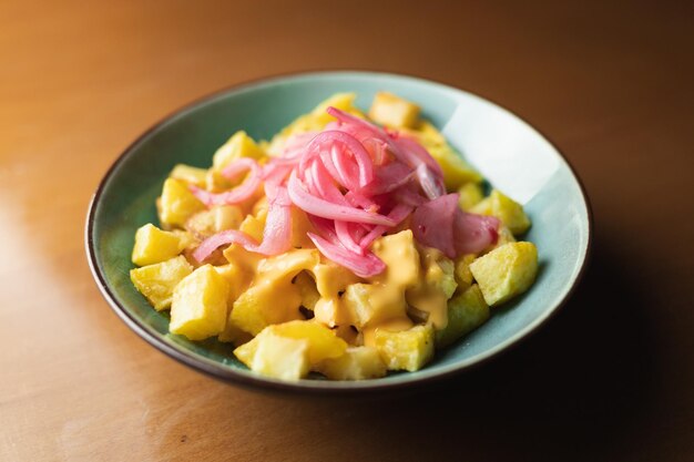 Photo pommes de terre épicées avec sauce à l'oignon et au fromage