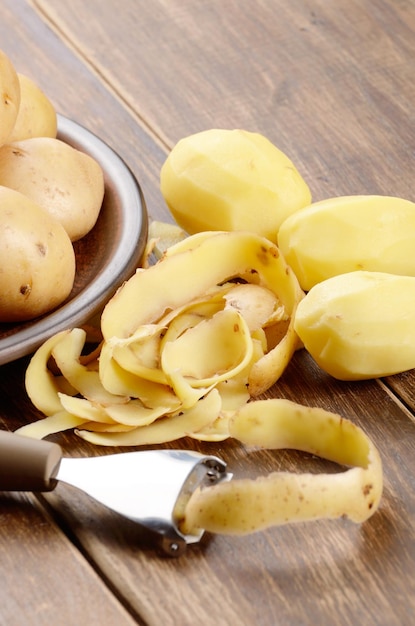 Pommes de terre épluchées sur la table en bois