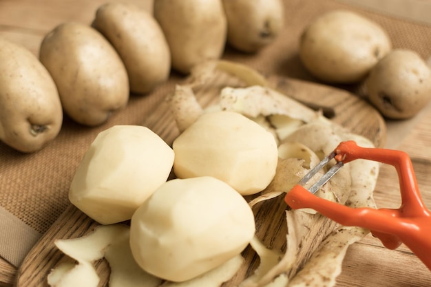 Pommes de terre épluchées de tubercules crus sur un fond en bois