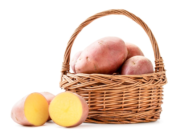 Pommes de terre fraîches et moitiés dans un panier gros plan sur fond blanc. Isolé