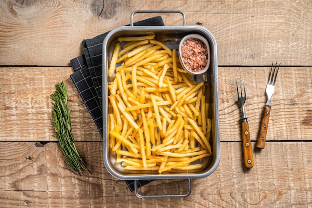 Pommes de terre frites frites avec du sel dans le bac de la cuisine Fond en bois Vue de dessus