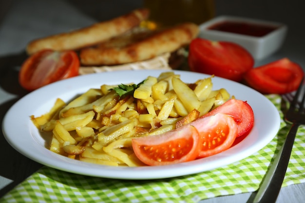 Pommes de terre frites Ruddy sur plaque sur table en bois libre