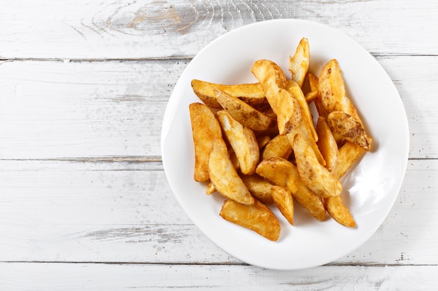 Pommes de terre frites tranches de chips sur table en bois