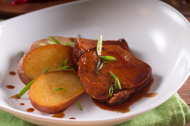 Pommes de terre frites et tranches de viande en sauce, plat de pays simple