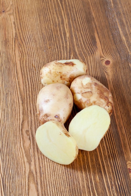 Pommes de terre mûries récemment lavées sur une table en bois