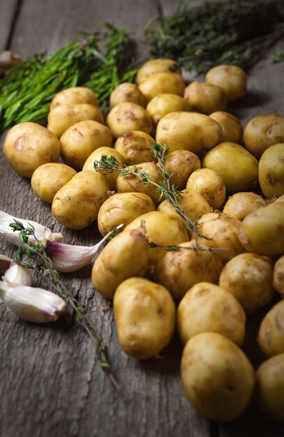 Pommes de terre nouvelles crues sur une planche à découper en bois