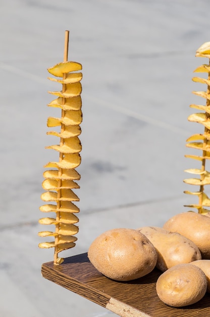 Des pommes de terre pelées et coupées dans un fond de légumes crus