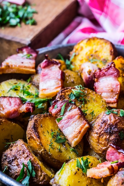 Pommes de terre rôties à l'américaine avec bacon fumé ail sel poivre cumin aneth persil décoration aux herbes