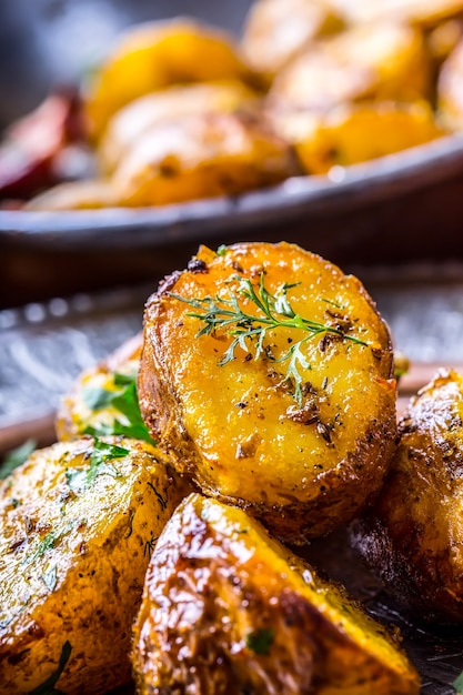 Pommes de terre rôties à l'américaine avec bacon fumé ail sel poivre cumin aneth persil décoration aux herbes