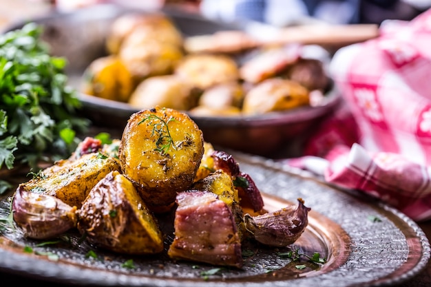 Pommes de terre rôties à l'américaine avec bacon fumé ail sel poivre cumin aneth persil décoration aux herbes