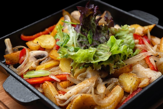 Pommes de terre sautées frites avec légumes et champignons dans une poêle en fonte mise au point sélective