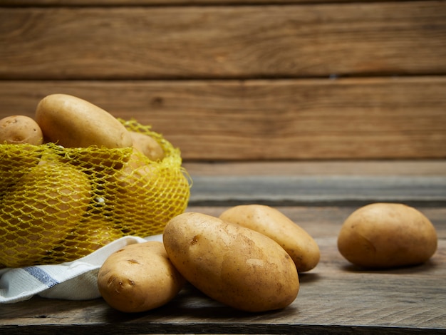 Pommes de terre sur une vieille table en bois.