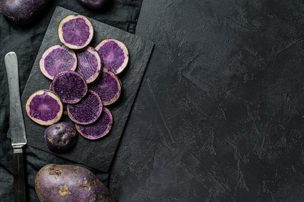 Pommes de terre violettes tranchées crues. Vue de dessus.