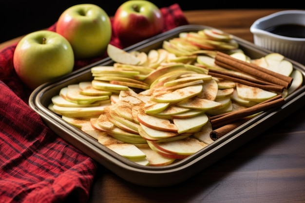 Des pommes tranchées et des bâtons de cannelle sur un plateau