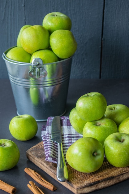 Pommes vertes dans un seau et sur une table