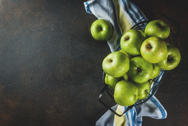 Pommes vertes de ferme biologique crue fraîche dans un panier en métal noir, rouillé foncé, copyspace vue de dessus