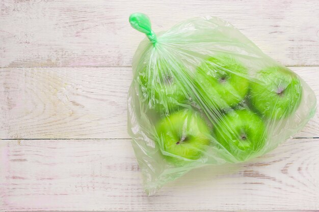 Pommes Vertes Fraîches Dans Un Sac En Plastique Sur La Table En Bois. Concept Environnemental De L'utilisation Non écologique Du Plastique