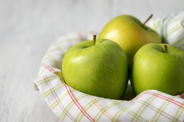 Photo pommes vertes en gouttes d'eau sur une table en bois