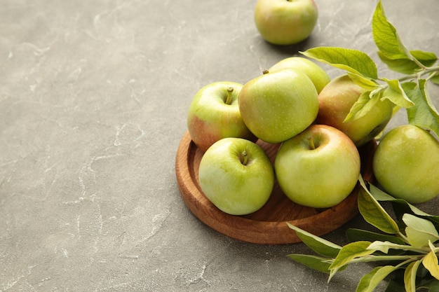 Pommes vertes mûres avec des feuilles vertes sur fond gris Vue supérieure