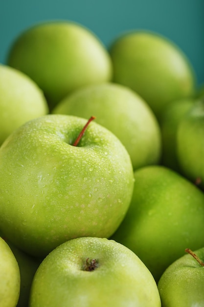 Pommes vertes mûres et juteuses sur fond vert.