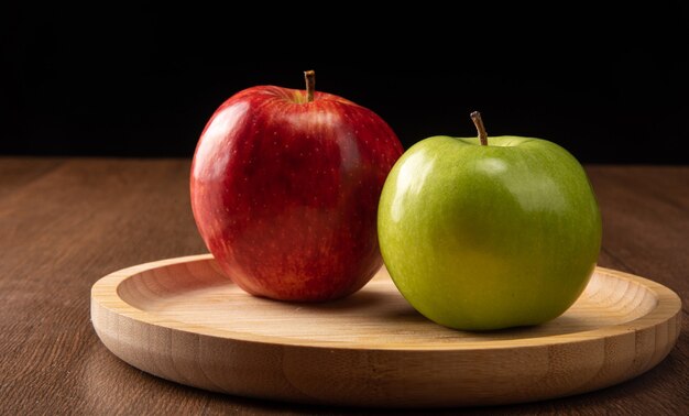 Pommes vertes et rouges positionnées sur bois
