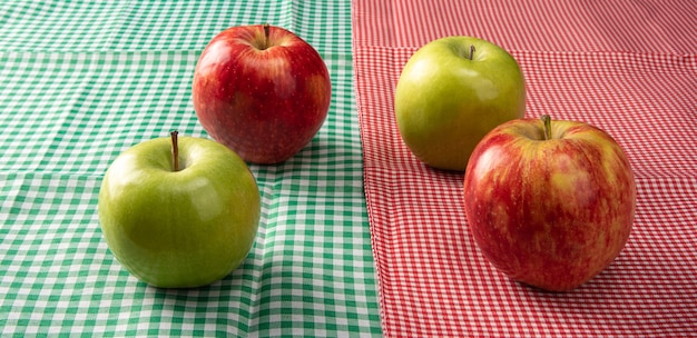 Photo pommes vertes et rouges positionnées sur des serviettes à carreaux