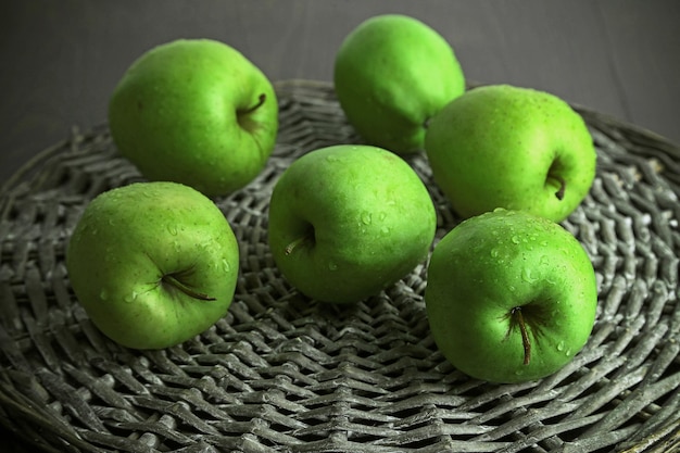 Pommes vertes sur tapis en osier libre